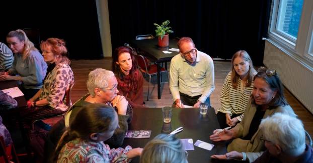 de deelnemers aan het involv theater praten in groepjes na